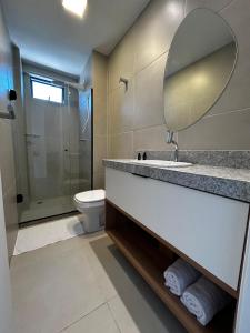 a bathroom with a sink and a mirror and a toilet at Beira-mar Tamandaré / Carneiros in Tamandaré