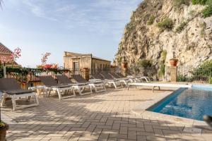 - une rangée de chaises à côté de la piscine dans l'établissement Hotel Corallo, à Taormine