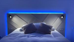 a bed with a blue light on top of it at Lilou Home - Appartement proche Disneyland Paris in Ferrières-en-Brie