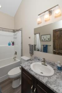 a bathroom with a sink and a toilet and a mirror at Summit View in Valemount