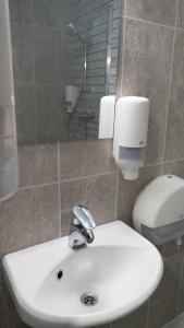 a bathroom with a white sink and a shower at Tallinn Guest House in Tallinn