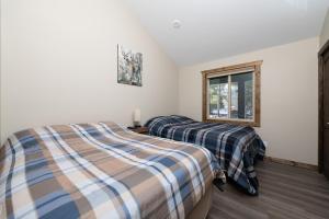 two beds in a room with a window at Summit View in Valemount