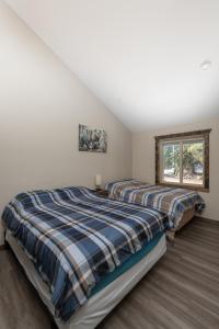 two beds in a bedroom with a window at Summit View in Valemount