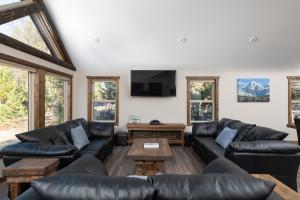 ein Wohnzimmer mit Ledersofas und einem Flachbild-TV in der Unterkunft Summit View in Valemount