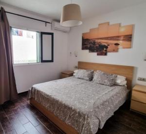 a bedroom with a bed and a painting on the wall at 118 Portonovo in Puerto del Carmen