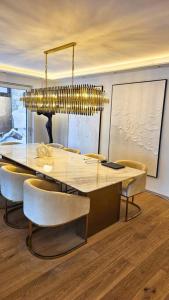 uma mesa de jantar com cadeiras e um lustre em Luxurious 150m² Home + Pool + Garden em Munique