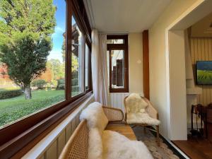 a room with a window with a chair and a couch at Stuttgart 210 - Apê em Gramado em local tranquilo in Gramado