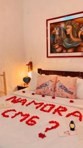 a bed with red rose petals on it at Olho D'Água Pousada in Guaramiranga