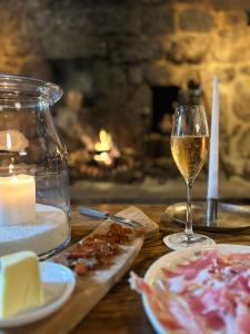 - une table avec un verre de vin et du fromage dans l'établissement La Maison de Paul en Aubrac - Lozère, à Fontans