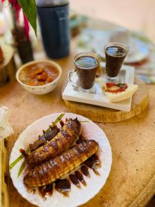 einen Tisch mit zwei Teller Essen und zwei Würstchen in der Unterkunft Olho D'Água Pousada in Guaramiranga