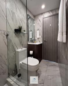 uma casa de banho com um WC e uma cabina de duche em vidro. em H New Apartment, Great Hosts and Location na Cidade do Panamá