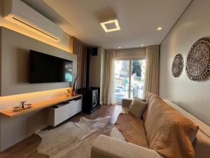 Uma TV ou centro de entretenimento em Reserva das Orquídeas 304B - Borges Centro Gramado