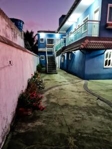 uma escada que conduz a um edifício com paredes azuis em Nacif&Alcantara Suítes em Tamoios
