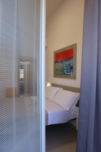 a bedroom with a bed and a window with blinds at Ruffini Rooms in Termoli