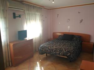 a bedroom with a bed and a cross on the wall at Apartamento Nandy e Isa in Caleta De Velez