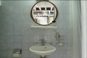 W łazience znajduje się umywalka i lustro. w obiekcie Maison sur cour w Paryżu