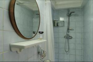 W łazience znajduje się prysznic, umywalka i lustro. w obiekcie Maison sur cour w Paryżu