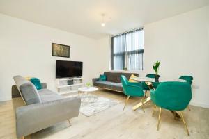 een woonkamer met een bank en een tafel en stoelen bij Apartment by DH ApartHotels in Peterborough