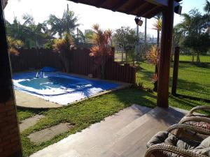 un patio trasero con piscina y valla en casa praia, en Arroio do Sal