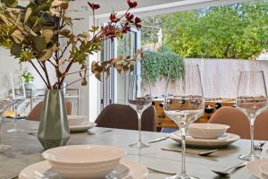 uma mesa com copos de vinho e pratos em Luxury Detached New 5 Bedroom House Ascot - Parking Private Garden em Winkfield