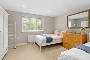 um quarto com 2 camas, um espelho e uma cómoda em Luxury Detached New 5 Bedroom House Ascot - Parking Private Garden em Winkfield