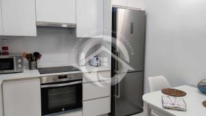 a kitchen with a stainless steel refrigerator and a table at Alcala' Mendez Home in Alcalá