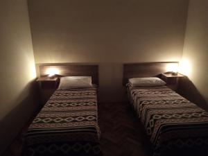 2 camas en una habitación pequeña con 2 lámparas en Nilo en San Rafael