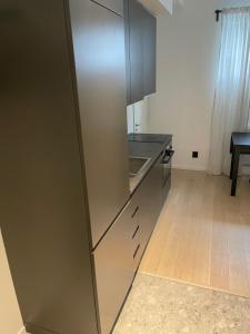 a kitchen with a stainless steel refrigerator and a wooden floor at 2- bed Apartment in Sollentuna in Sollentuna