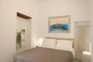 a bedroom with a bed and a painting on the wall at Ruffini Rooms in Termoli