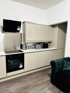 una cocina con armarios blancos y horno negro en Luxurious & modern large house 9mins drive to town en Beeston Hill