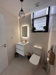 a bathroom with a toilet and a sink and a mirror at Papá Totë Deluxe in Playa Honda