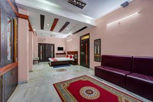 una sala de estar con un sofá púrpura en una habitación en OYO Flagship Wellfood Inn, en Patna