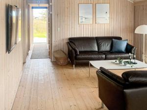 ロンストラップにあるTwo-Bedroom Holiday home in Hjørring 1のリビングルーム(革張りのソファ、テーブル付)