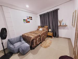 um quarto com uma cama e uma cadeira em Dezra Homes em Lagos