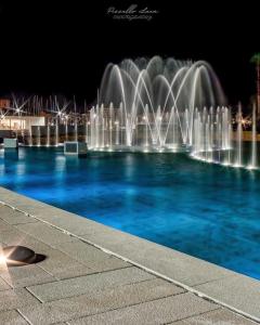 un grupo de fuentes de agua iluminadas por la noche en Porta Amari, en Palermo
