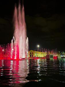 a fountain in the middle of the water at night at Porta Amari in Palermo