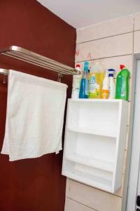 a white cabinet with cleaning products in a bathroom at Somptueux Studio au cœur de Douala in Douala