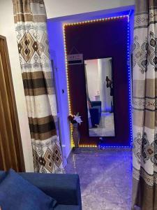 a blue room with a mirror and a cat standing in a bathroom at Somptueux Studio au cœur de Douala in Douala