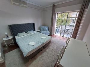um quarto com uma cama, uma cadeira e uma janela em Lisbon`s best at Campo Pequeno em Lisboa
