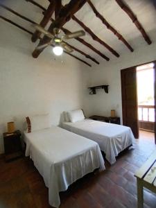 1 dormitorio con 2 camas y techo en Casona CHARA, en Barichara