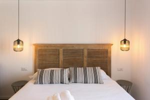 1 dormitorio con 1 cama con 2 almohadas y 2 luces en Navigli - Vigevano 45 & Casale 3a studios, en Milán 2 fotos más