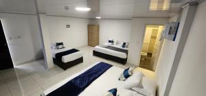 a hotel room with two beds and a mirror at Edificio Regata INN in Buenaventura
