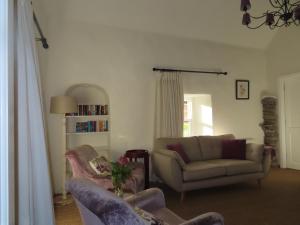 a living room with two chairs and a couch at The Humble Daisy in Woodford