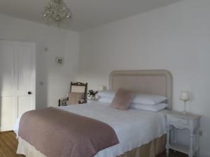 a bedroom with a bed and a table with a chair at The Humble Daisy in Woodford