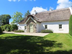 un cottage bianco con tetto di paglia di The Humble Daisy a Woodford