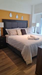 1 dormitorio con 1 cama grande con sábanas y almohadas blancas en Torre Pamplona 102-Nuevo y Céntrico-Apartamento en Guatemala