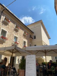 Merlin Malga San Giorgio 6 في بوسكو تيسانيوفا: مطعم فيه مظلات امام مبنى +8 صور