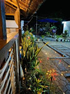 un giardino con piante e una recinzione di notte di Solwara Beach Resort a Balete