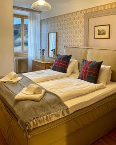 a bedroom with a large bed with towels on it at DU GLACIER Boutique & Traditions Hotel in Fiesch