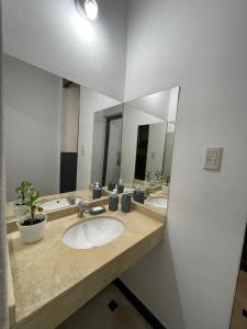 a bathroom with two sinks and a large mirror at DOS SANTOS HOSTEL in Salta